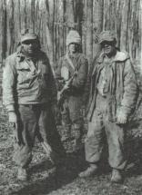 Un soldat din Divizia 21 Infanterie cu doi prizonieri germani. Contrastul dintre echipamentul lor si tinuta romanului este evidet