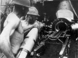 Servanti la un obuzier greu Skoda, md. 1934, calibrul 150 mm. Acestia poarta casti de tip Adrian, md. 1916, specifice trupelor auxiliare. Basarabia, iulie 1941.