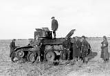 Mountain troops posing around an abandoned Soviet BT-5 tank.